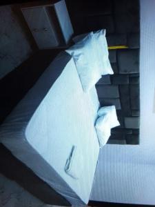 a bed with white sheets and pillows on it at Light house hotel and apartments Lekki phase 1 in Lekki