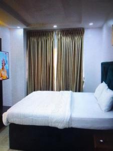 a bedroom with a large white bed and a window at Light house hotel and apartments Lekki phase 1 in Lekki