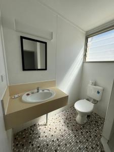 Cairns City Motel في كيرنز: حمام مع حوض ومرحاض