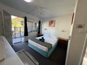 a hotel room with a bed and a balcony at Cairns City Motel in Cairns