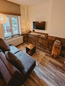 sala de estar con sofá y TV de pantalla plana en Maas Suites (Maastricht - Lanaken), en Lanaken