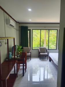 um quarto com uma cama, uma mesa e cadeiras em Dokchampa Hotel em Vang Vieng