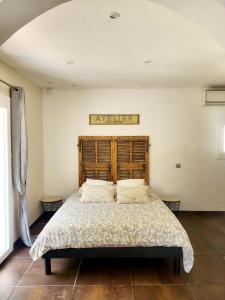 1 dormitorio con 1 cama grande y cabecero de madera en Lou mas del ranc, en Roquestéron