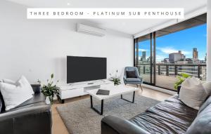 a living room with a couch and a tv at Melbourne Lifestyle Apartments – Best Views on Collins in Melbourne