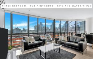 Melbourne Lifestyle Apartments – Best Views on Collins في ملبورن: غرفة معيشة مطلة على المدينة