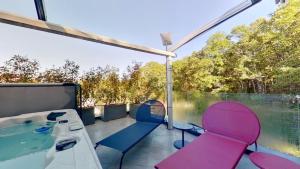 een kamer met een hot tub en stoelen op een balkon bij Maison Olivier in Veigy-Foncenex