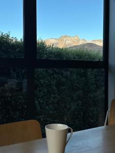 a coffee cup sitting on a table in front of a window at Home Away from Home in Queenstown