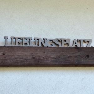 a wooden sign with the word internationalagency on a wall at Petite Noel in Güssing