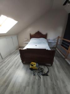 1 dormitorio con cama y aspiradora en el suelo en Maison d'hôte Domoland, en Olby