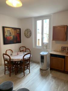 a kitchen with a table and chairs and a clock on the wall at fontaine in Aups