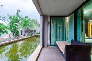 a balcony with a pool of water in a house at Tara Mantra Cha-Am Resort in Cha Am
