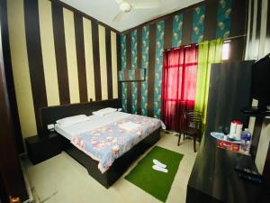 um quarto com uma cama e uma parede listrada em Hotel Regard em Varanasi