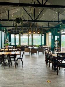 a dining room with tables and chairs and windows at Green Flower Hotel in Kutaisi