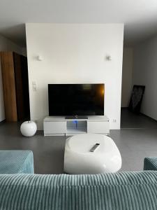 a living room with a tv and a couch at Schönes Apartment mit Terrasse - Privatvermietung in Waldstetten