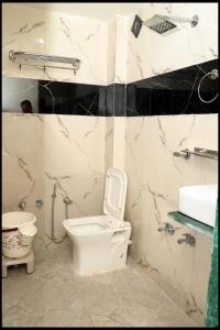 a bathroom with a toilet and a sink at Hotel Nest pride in Ahmedabad