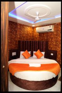 a bedroom with a large bed with orange pillows at Hotel Nest pride in Ahmedabad