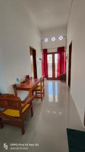 ein Wohnzimmer mit einem Holztisch und Stühlen in der Unterkunft Jatisela Homestay5 in Midang