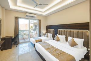 a hotel room with two beds and a window at Stone Wood Hotel, Rishikesh in Rishīkesh