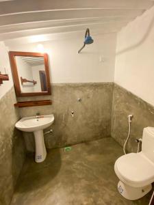 a bathroom with a toilet and a sink at Surfers Park Arugambay in Arugam Bay