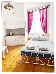 um quarto com uma cama com cortinas cor-de-rosa em SouvenirAppart Sniadeckich 45 em Bydgoszcz
