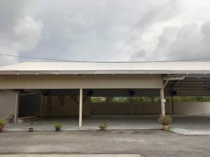 a large building with a garage with two potted plants at ASTANA SHAFIIS in Malacca