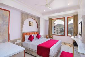 um quarto com uma cama grande e um cobertor vermelho em Trim Boutique Parkota Haveli em Jaipur