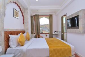 a hotel room with a bed with a television at Trim Boutique Parkota Haveli in Jaipur