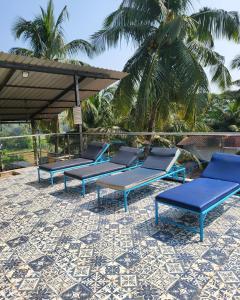 a row of blue benches sitting on a patio at Hotel heaven by sky in Calangute
