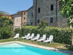 - un groupe de chaises assises à côté de la piscine dans l'établissement Holiday house with pool exclusive use, à Magnano