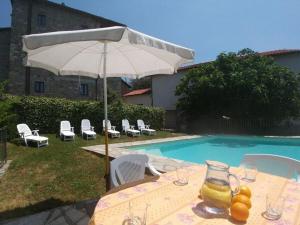 - une table avec un parasol à côté de la piscine dans l'établissement Holiday house with pool exclusive use, à Magnano