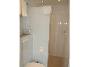 a bathroom with a toilet and a shower at Muijs Comfortable holiday residence in Huisduinen