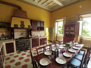 comedor con mesa y sillas y cocina en Historic villa near Florence, en Rignano sullʼArno