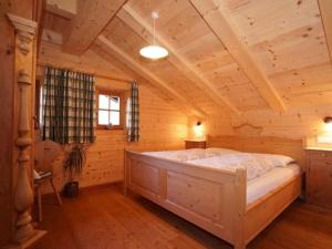 een slaapkamer met een bed in een blokhut bij Onderhabererhof in Gsies