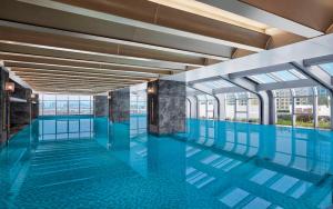 a swimming pool with blue floors and windows at Delta Hotels by Marriott Kunming in Kunming