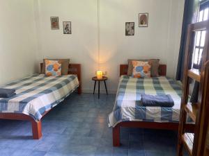 a room with two beds and a table with a lamp at Colibri Inn in Thong Sala +15 photos