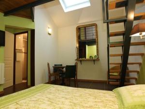 a bedroom with a bed and a room with a desk at Le Jardin de Norah in Brulange