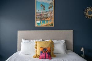 uma cama com almofadas brancas e uma fotografia de um resort em Stylish Beach Home - Moments from Water em Terrigal