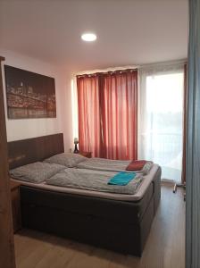 łóżko w sypialni z dużym oknem w obiekcie Ikon w Siófoku