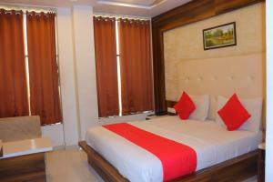 - une chambre avec un grand lit et des oreillers rouges dans l'établissement HOTEL LORDS IN, à Ahmedabad