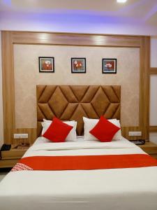um quarto com uma cama grande e almofadas vermelhas em HOTEL LORDS IN em Ahmedabad