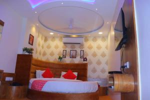 - une chambre avec un lit et des oreillers rouges dans l'établissement HOTEL LORDS IN, à Ahmedabad