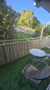 a table and a chair on a patio with a fence at Apartament Słoneczna Wydma in Ustka