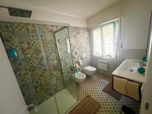 a bathroom with a shower and a toilet and a sink at VILLA TARA in Quercianella