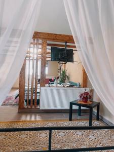 Una sala de estar con una mesa y un televisor. en Yard Studio Râșnov, en Râșnov