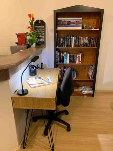 un bureau avec une chaise et une étagère avec des livres dans l'établissement Acgated Parking North Adelaide Balcony Suite, à Adélaïde