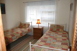 sypialnia z 2 łóżkami i lampką na stoliku nocnym w obiekcie Comfortable Unit Close to the Beach w mieście Victor Harbor