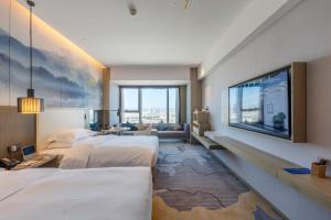 Delta Hotels by Marriott Kunming في كونمينغ: غرفة فندقية بسريرين وتلفزيون بشاشة مسطحة