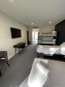 Zimmer mit 2 Betten, einem Schreibtisch und einem TV in der Unterkunft Harden Country Club Motel in Harden