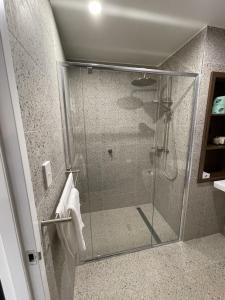 a shower with a glass door in a bathroom at Harden Country Club Motel in Harden