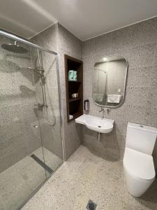 bagno con servizi igienici, lavandino e specchio di Harden Country Club Motel a Harden